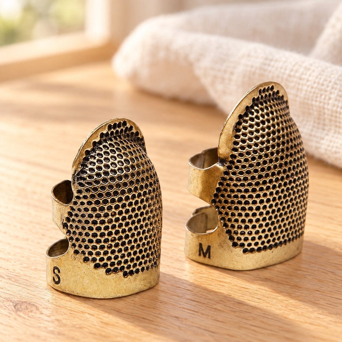 AI-styled: Adjustable Sewing Thimbles — S & M Pair on a warm oak craft desk. Styling props are not included.