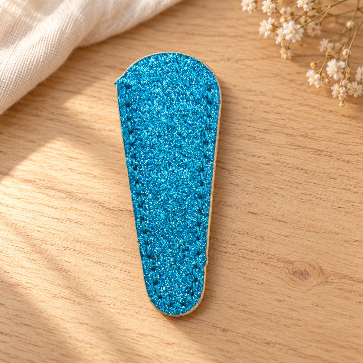 AI-styled: Blue Glitter Scissor Sheath on a warm oak craft desk. Styling props are not included.