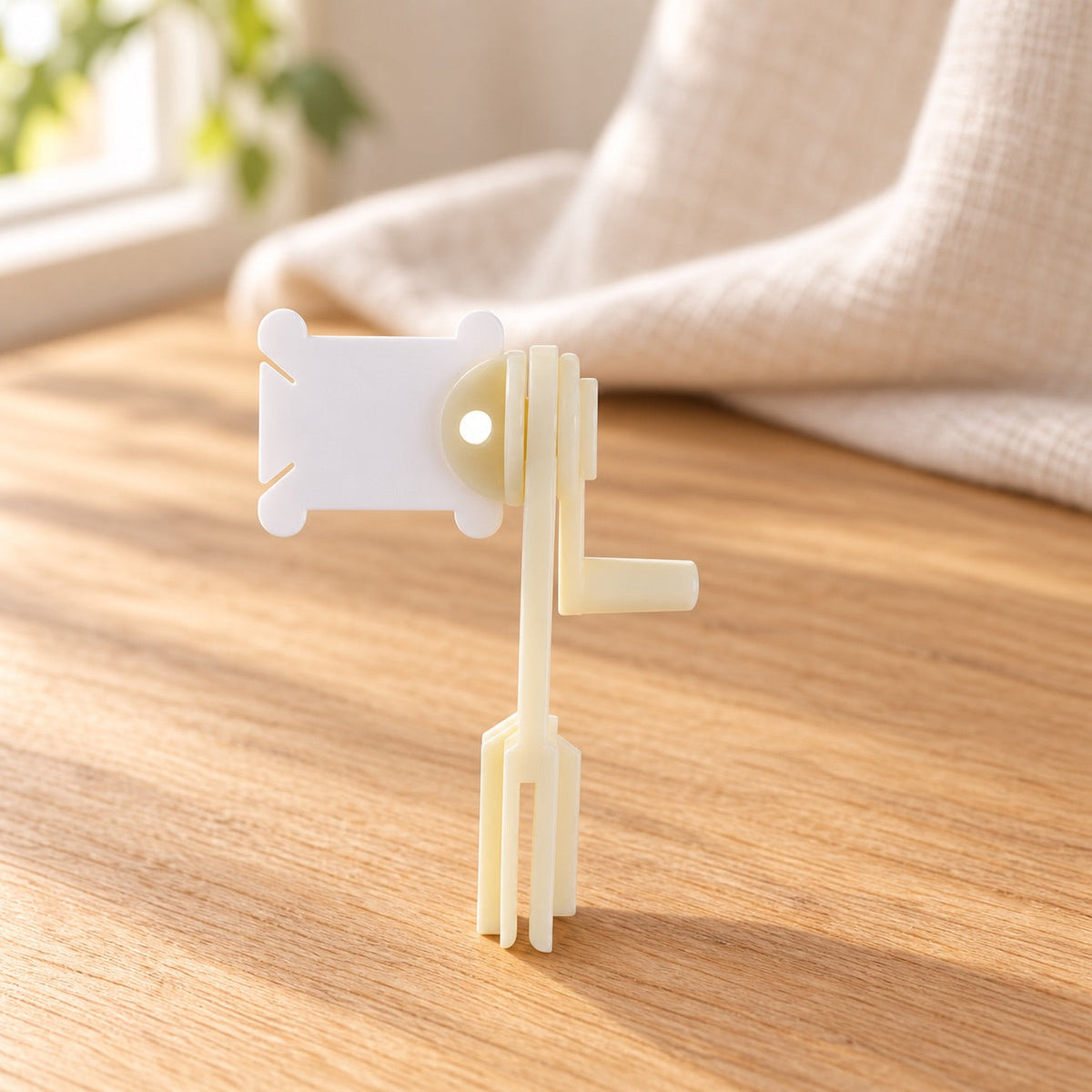 AI-styled: Manual Embroidery Floss Bobbin Winder on a warm oak craft desk. Styling props are not included.