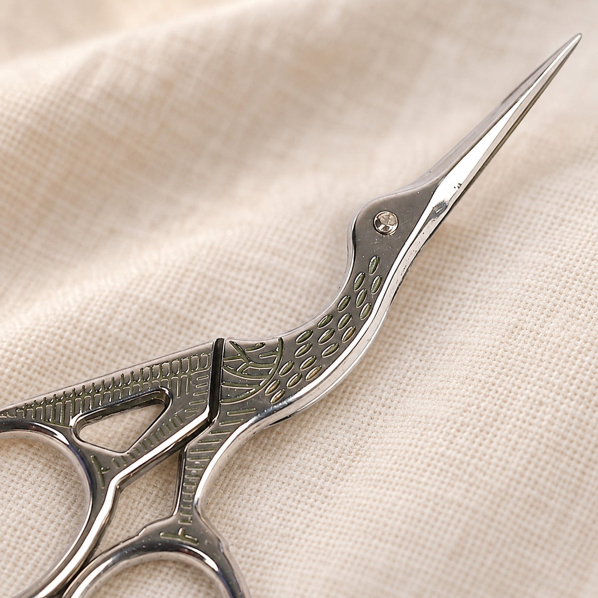 AI-styled: Silver Stork Embroidery Scissors — close view of the original product details. Styling props are not included.
